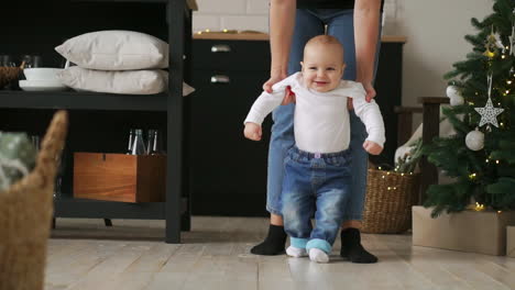 Closeup-of-mothers-and-baby's-feet-walking-on-wooden-floor-at-long-hallway