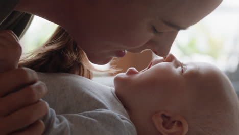 close up mother kissing happy baby laughing enjoying loving mom nurturing toddler at home