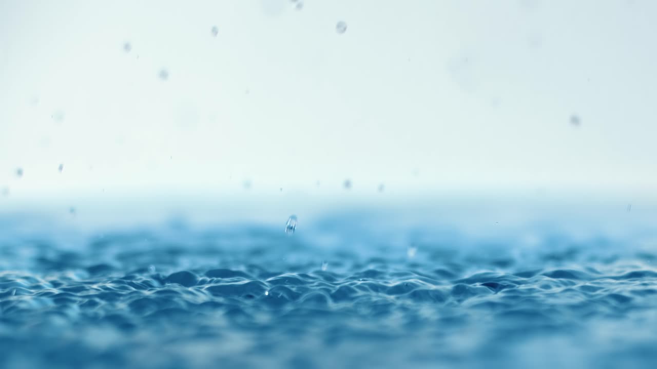 Rain water drops falling in super slow motion.