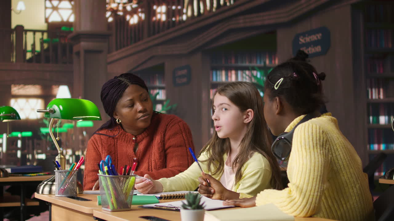 학생들이 도서관에서 교사와 협력하고 있습니다.