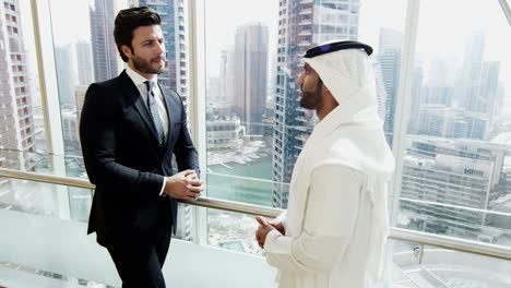 middle eastern and caucasian businessmen meeting downtown building