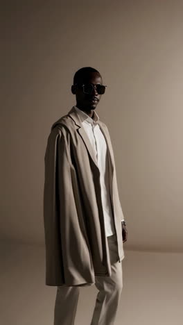 stylish man in a beige coat and sunglasses