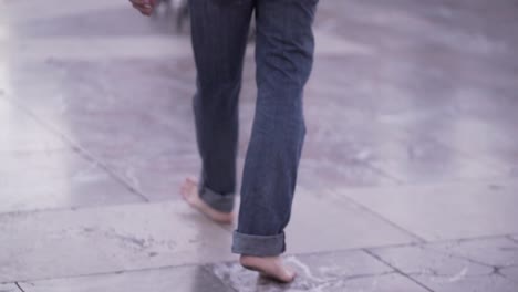 barefoot person walking on stone tile floor