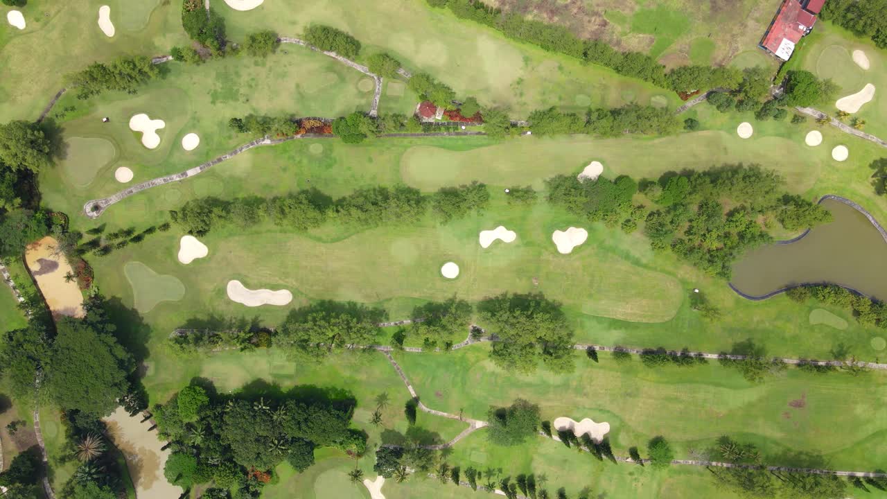 Directly top down view of golf course with water hazard and bunker