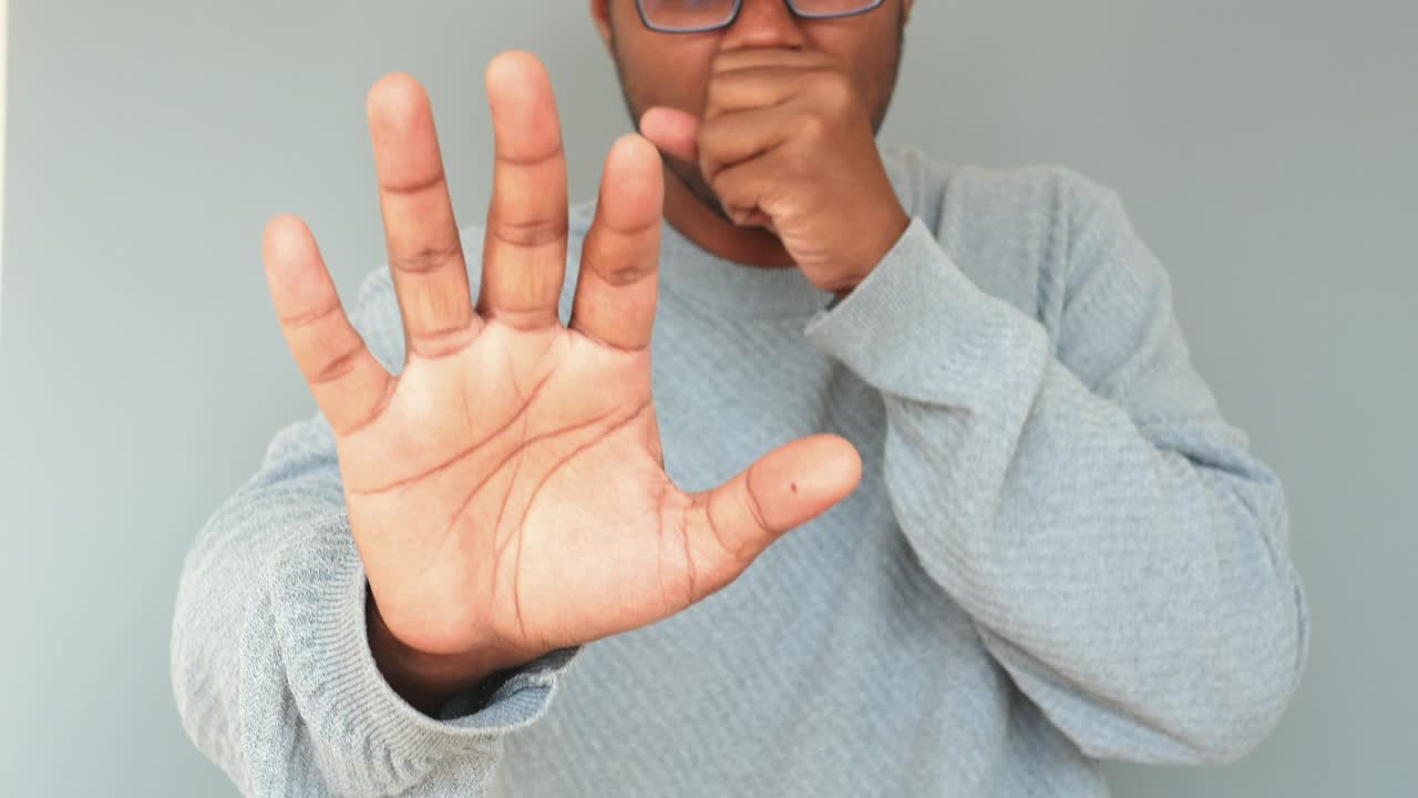 기침을 하고 멈추는 몸짓을 하는 사람