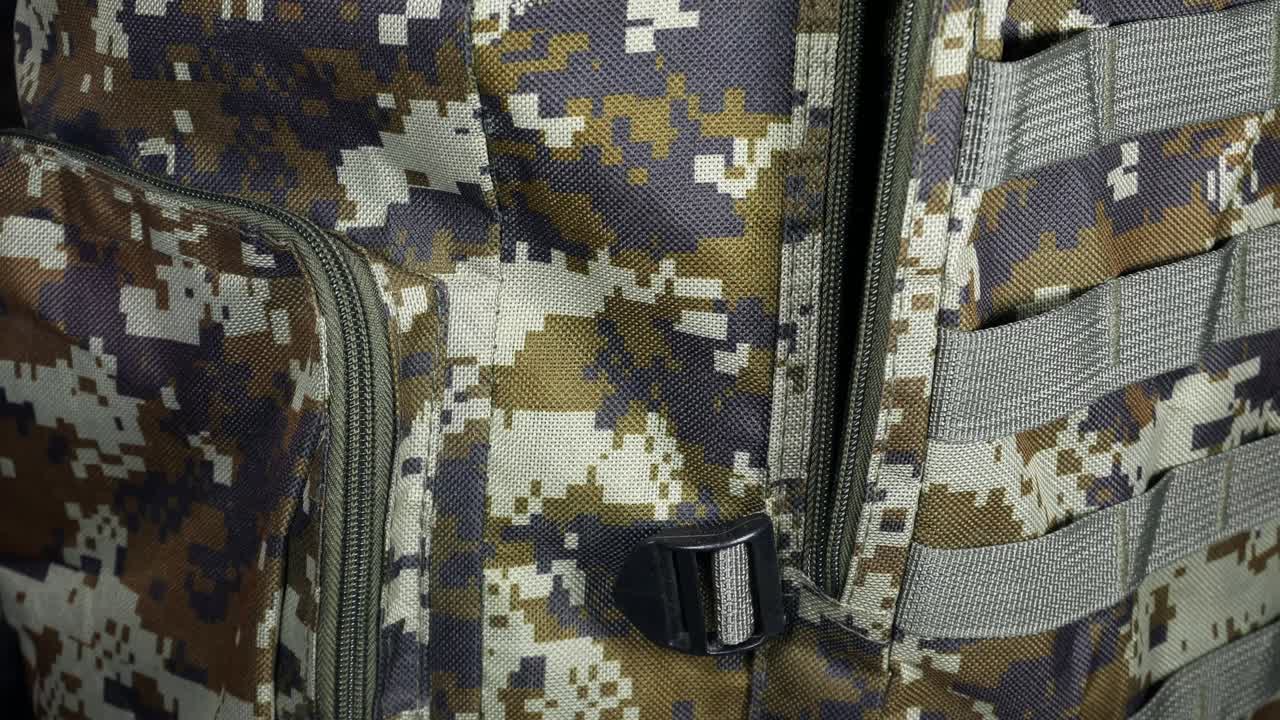 hombre está poniendo en una mochila militar dólares. verde oscuro camuflaje bolsa de caqui con dinero. migrantes y refugiados. saqueo y concepto de robo.