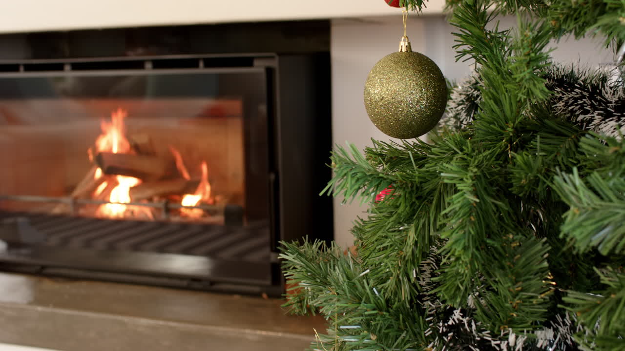 Cozy fireplace glowing with Christmas tree ornament in warm holiday setting, copy space