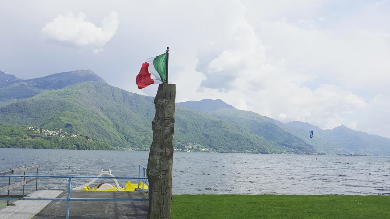Una bandiera in primo piano con un windsurfista sullo sfondo sul meraviglioso Lago di Como in Italia