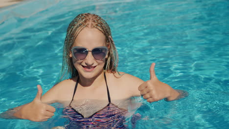 portrait of a child in the pool, looking into the camera, smiling