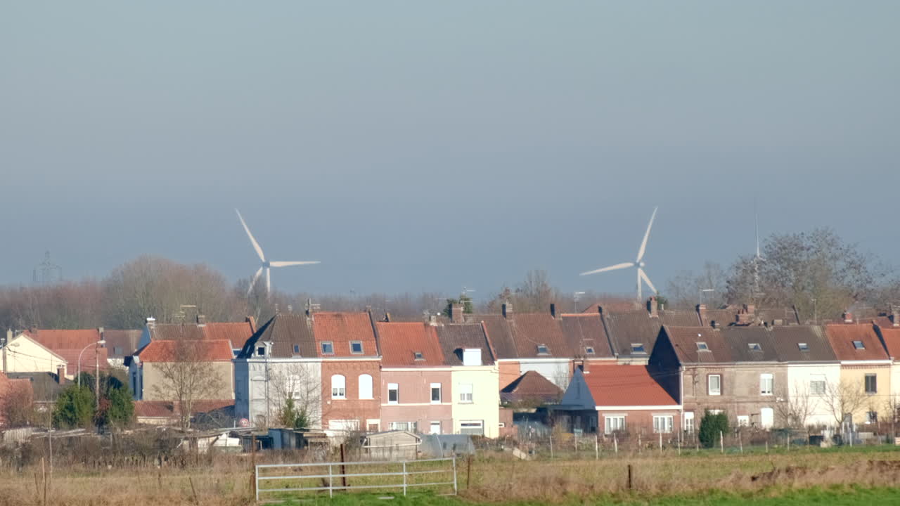 Wind turbines rotating behind a small french village