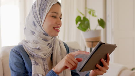 Glückliche-Biracial-Frau-Im-Hijab-Mit-Tablet-Auf-Dem-Sofa-Zu-Hause-Mit-Kopierplatz,-Zeitlupe