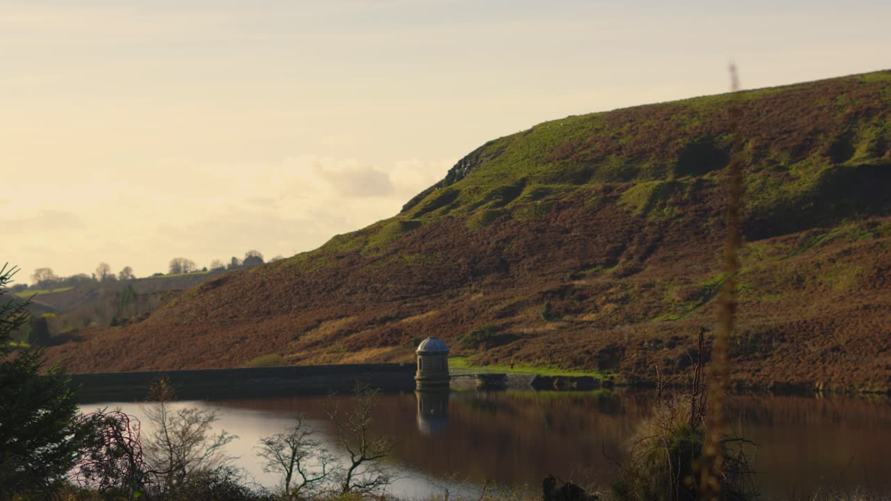 Static Shot of Upper Lliw Reservoir with Dam Wall and Steep Hill. Surrounded by Natural Plants, Trees and Foliage. Water Storage for Drinking After Processing at Treatment Plant