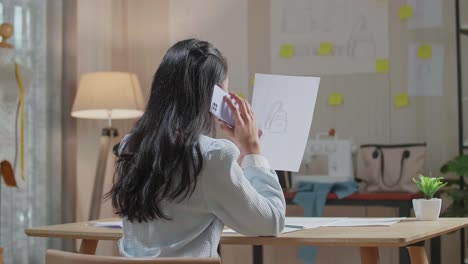 여성 디자이너가 드백을 보고 스마트폰으로 대화하는 모습
