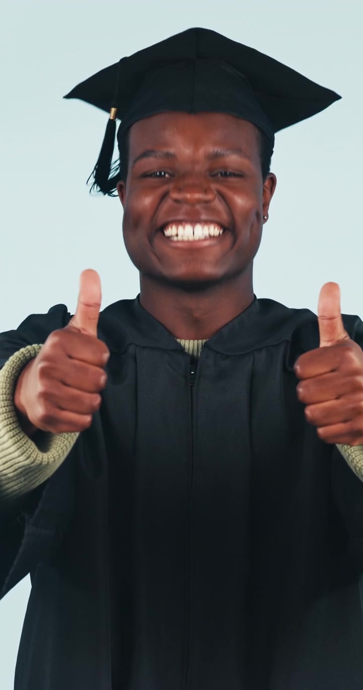 Happy Graduate Giving Thumbs Up in Graduation Gown