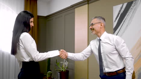 happy woman giving resignation letter to the male boss who wishes her good luck