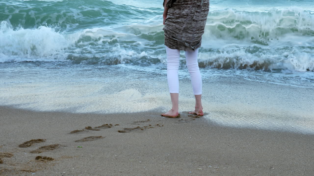 Woman feet in the day running from the waves