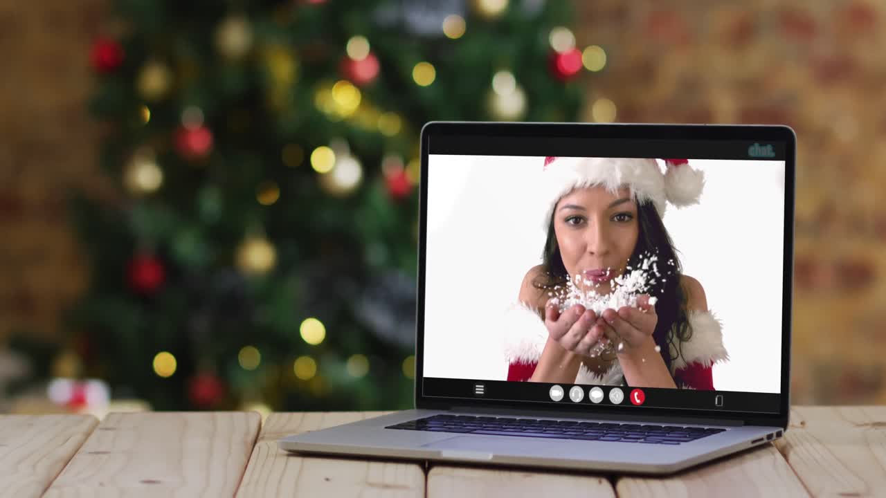 feliz mujer caucásica en disfraz de santa en videollamada en computadora portátil, con decoraciones de navidad y árbol