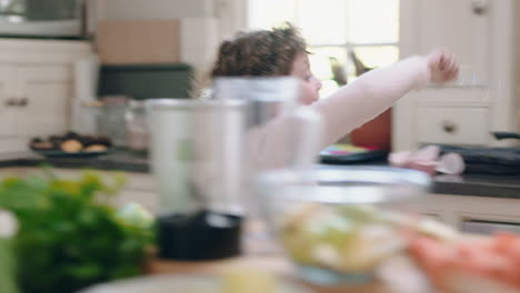 niña feliz bailando en la cocina divirtiéndose agitando la varita mágica jugando fingiendo haciendo movimientos de baile divertidos disfrutando del fin de semana en casa