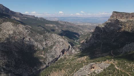 aerial view of the valley formed between large mountains with a drone, forest view