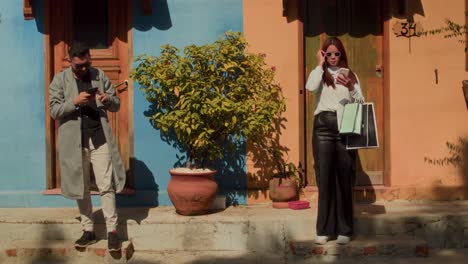 couple taking selfies and using phones in a colorful urban setting