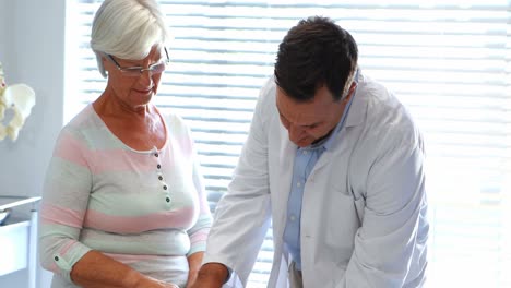 fisioterapeuta dando terapia de rodilla a una mujer mayor
