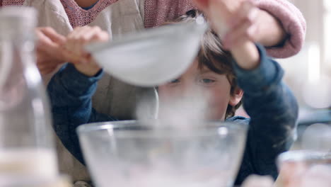 Kleiner-Junge-Hilft-Mutter-Beim-Backen-In-Der-Küche,-Mischt-Zutaten,-Sieben-Mehl-Mit-Einem-Sieb-Und-Bereitet-Zu-Hause-Ein-Rezept-Für-Cupcakes-Vor