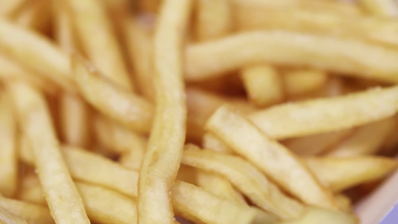 A man picking up twice and more french fries from the others