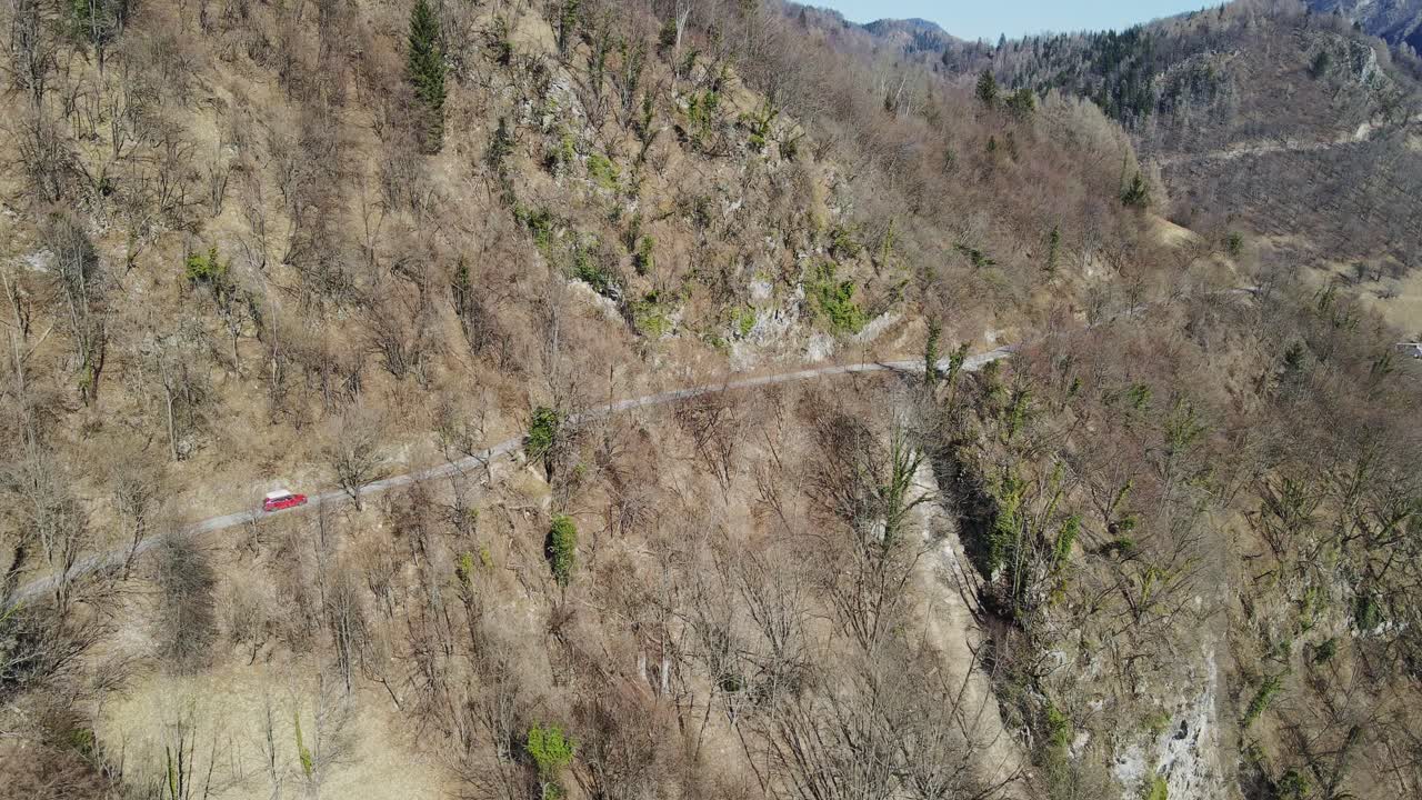 Drone of a car driving steep, winding roads from Grant to Koritnica in Slovenia