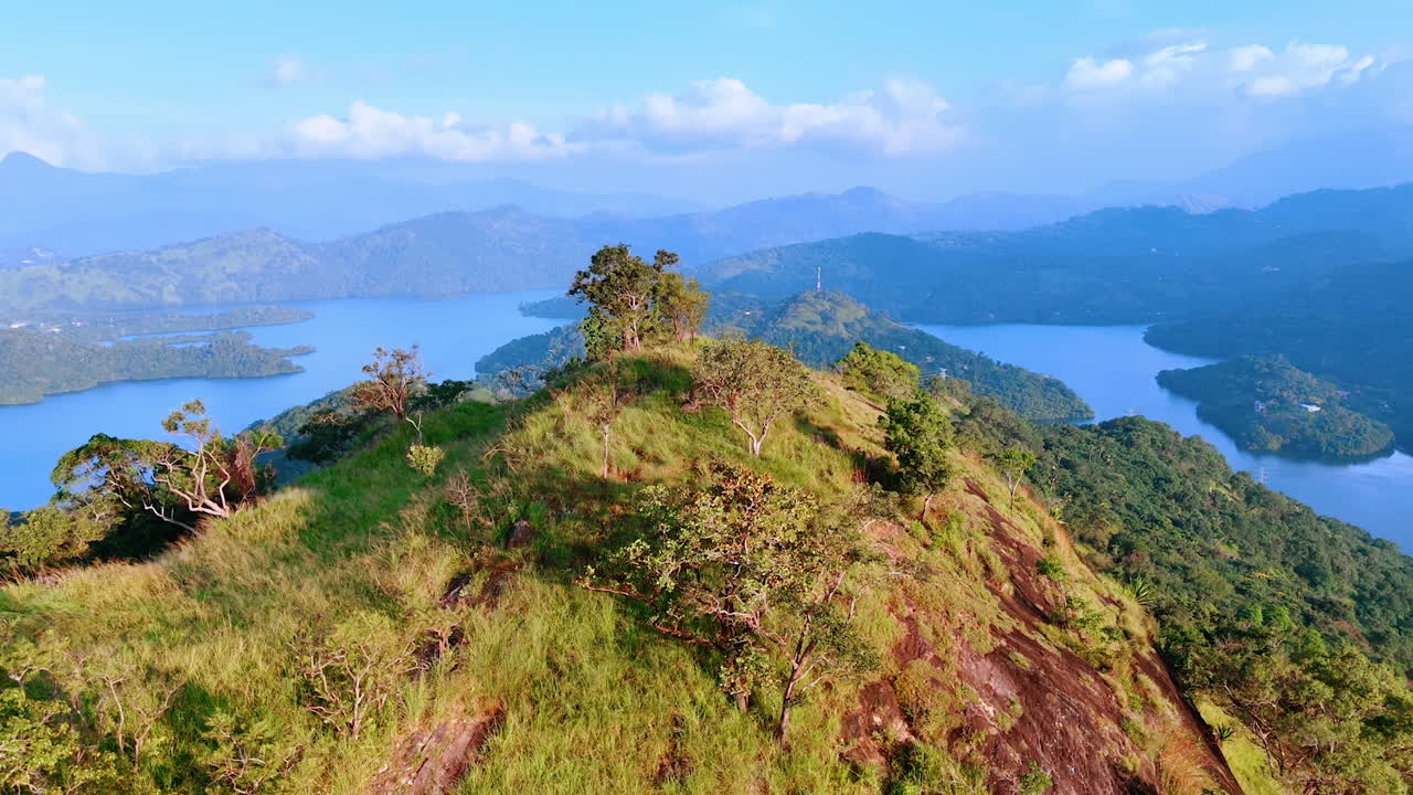Beautiful scenery of green mountains with waterscape at the foot. Thick fog covers the view at backdrop. Fantastic nature of Sri Lanka, South Asia.