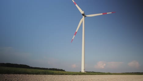 Wide-shot-of-a-spinning-windmill-in-the-field