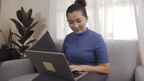 businesswoman authentic shot using a laptop to work from home happily