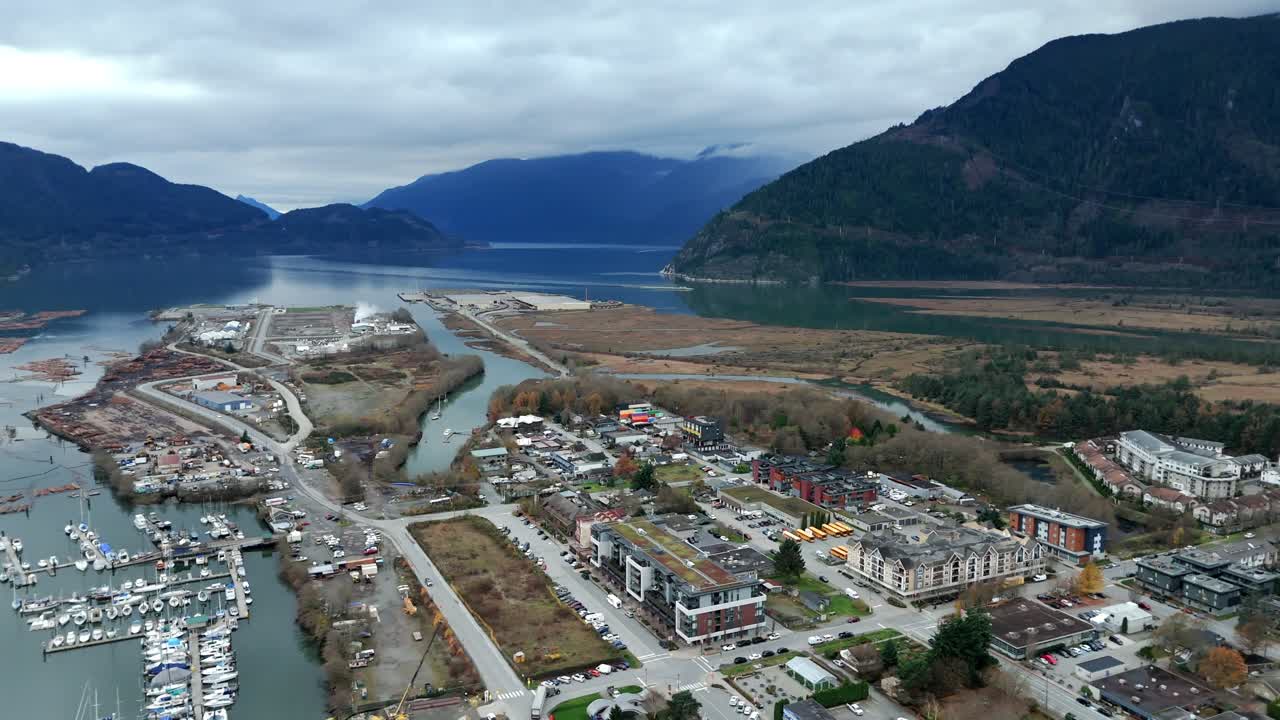 Edifici industriali e residenziali con marina nel centro di Squamish sull'Howe Sound in Canada. Ripresa aerea laterale.
