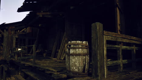 old wooden building with worn porch and rustic barrel in sunset light