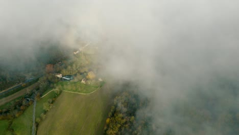 cultivated fields in the morning mist, drone shot with descent to the ground
