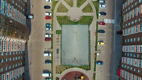 City life in modern complex. Comfortable playground and car parking between the apartment buildings of the urban district. Top down view.