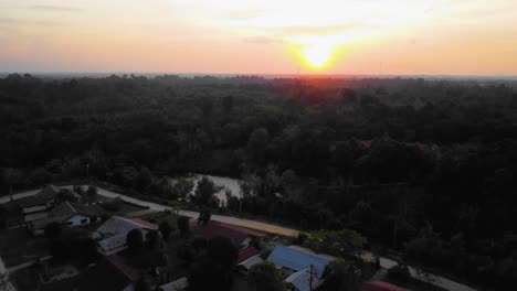 amazing cinematic 4k sunset residential drone footage after deforestation issue consists of homes, road, trees, lake and infrastructure in the middle of tropical forest located in riau, indonesia