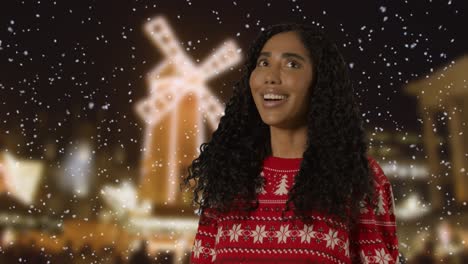 Woman-Wearing-Christmas-Jumper-Standing-Outside-At-Night-With-Falling-Snow