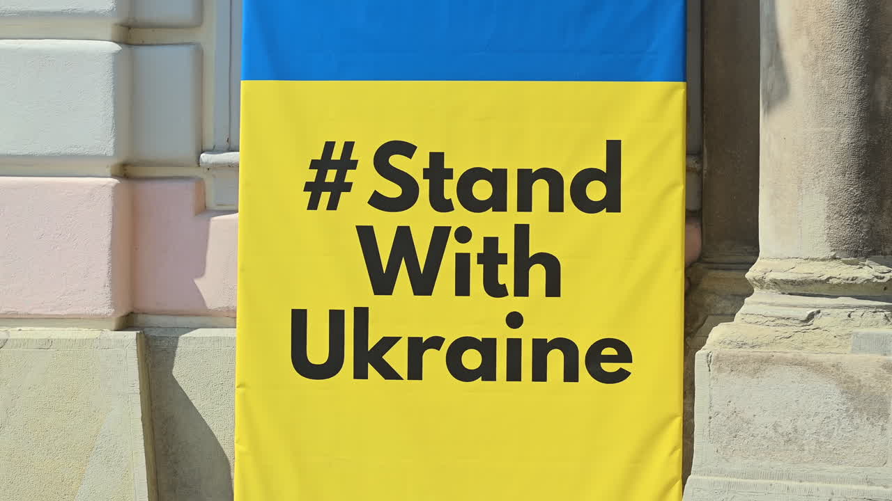 Cartello e bandiera con la scritta "Stand with Ukraine" in una strada di Sibiu, Romania