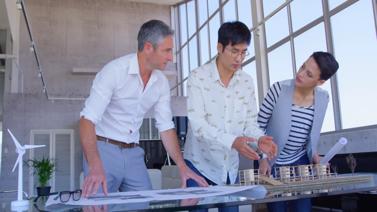 현대 사무실 4k에서 공장 모델에 대해 논의하는 다민족 사업가들