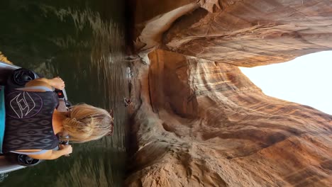 vertical slow motion of woman driving jet ski along lake powell narrow cliffs