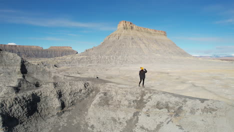 Aerial-View-of-Happy-Woman-Dancing-on-Top-of-Sandstone-Hill,-Celebrating-Achievement,-Drone-Shot