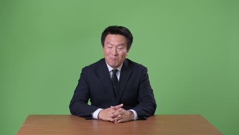 녹색 배경에 성숙한 일본 사업가