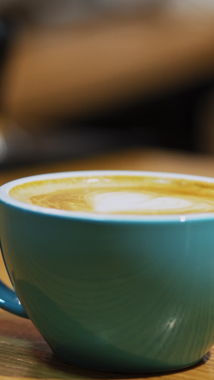Cup of coffee on wooden table. Barista selling coffee to consumer in cafe