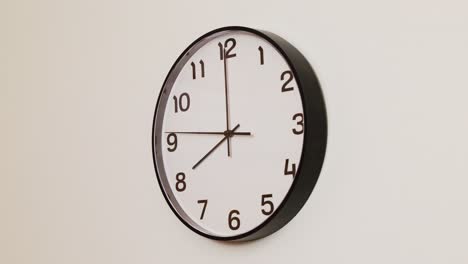 a close-up 4k shot of a black and white wall clock filling the frame, showing the time as 8:00.