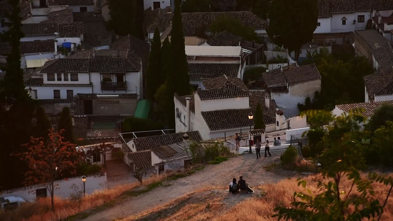 Romantic view over Granada’s Albaicín, where the ancient architecture and evening light create a truly cinematic scene. Hazy vibrant orange colors make . View from San Miguel Alto