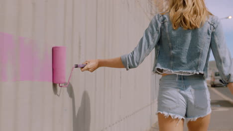 sexy woman painting wall with pink paint walking in city street confident female artist enjoying creative expression with urban graffiti art retro