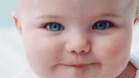 close up portrait of happy baby boy sitting on parents bed