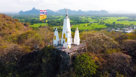 white temple on top of a mountain in thailand, 180 degree drone shot