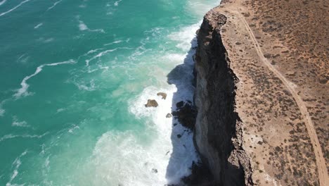 dron aéreo moviéndose hacia adelante con pan arriba sobre la gran bahía australiana con olas que se estrellan