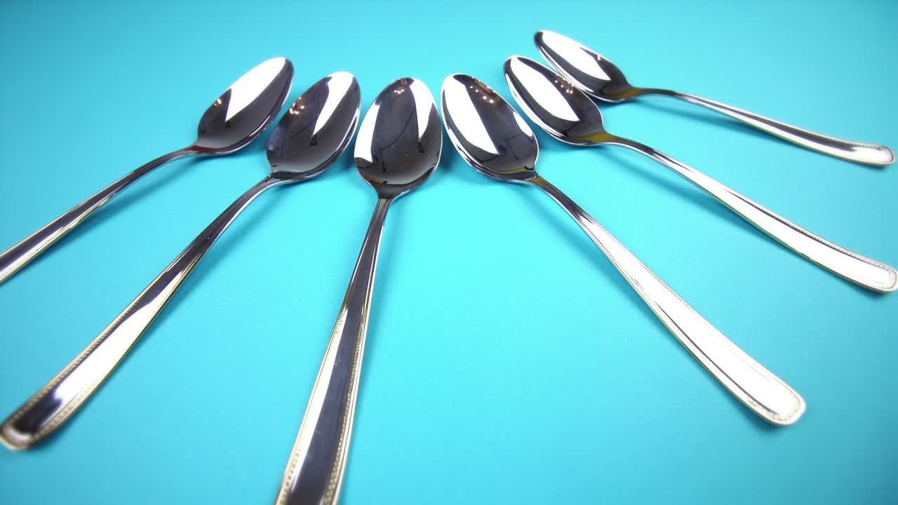 cucharas de plata limpias con mangos decorados en azul claro